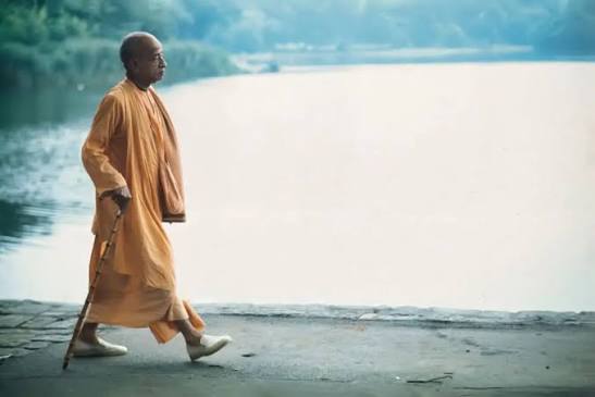 Srila Prabhupada geht am Ufer eines Sees entlang